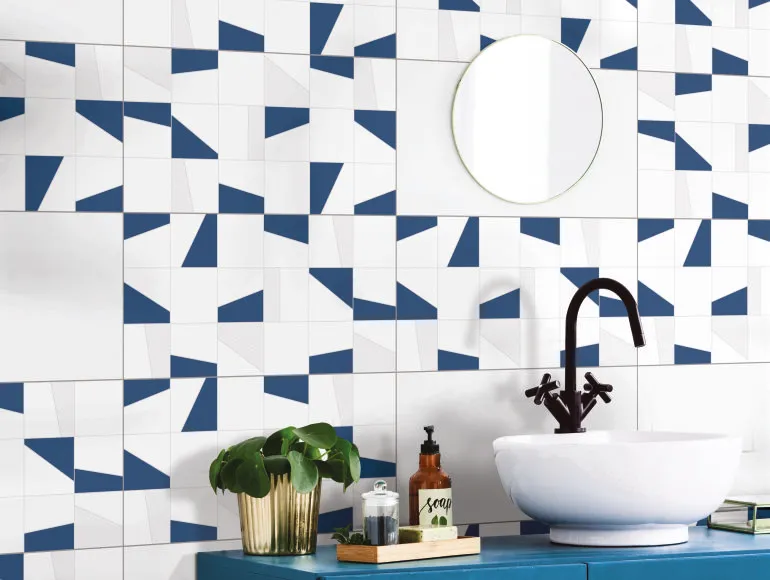 Blue bathroom design with countertop sink and round mirror above